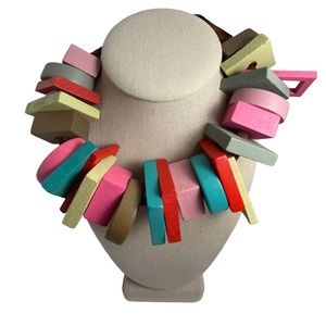 Multi colored wood necklace with brown ribbon to closure.